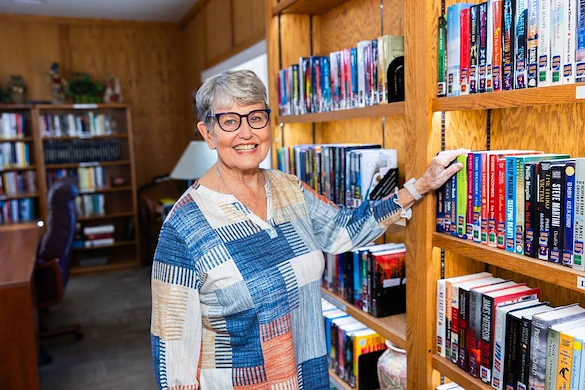 Resident enjoying the library at Fellowship Square Mesa