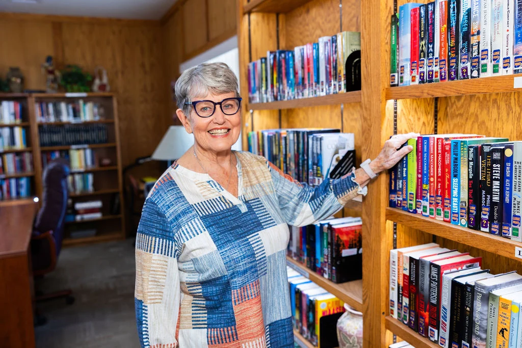 Resident enjoying the library at Fellowship Square Mesa