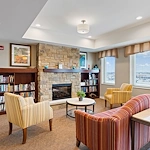 Alto Grayslake, senior living community offering assisted living, memory care, and respite care in Grayslake, IL, library and sitting area by a fireplace