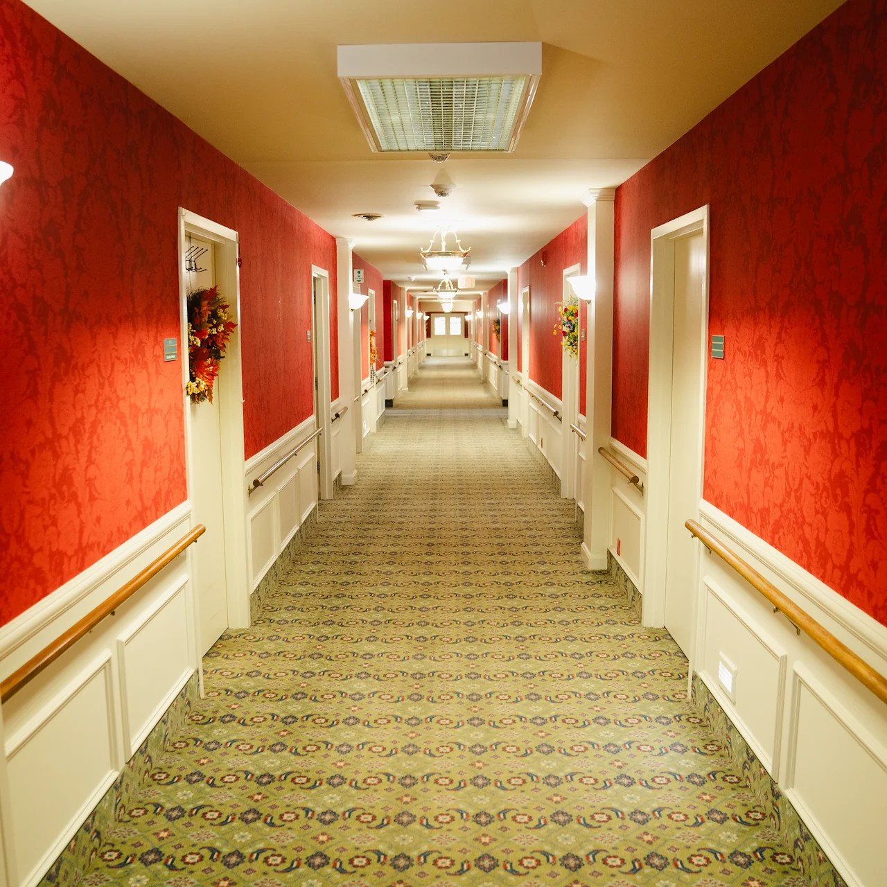 Wesley Manor Assisted Living Community offering assisted living and continuing care retirement community (CCRC) services in Louisville, KY, hallway with red wallpaper