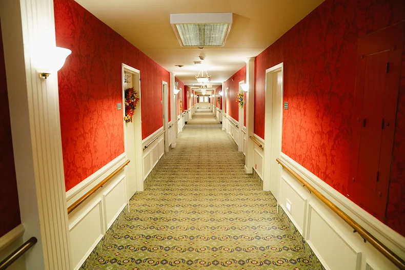 Wesley Manor Assisted Living Community offering assisted living and continuing care retirement community (CCRC) services in Louisville, KY, hallway with red wallpaper