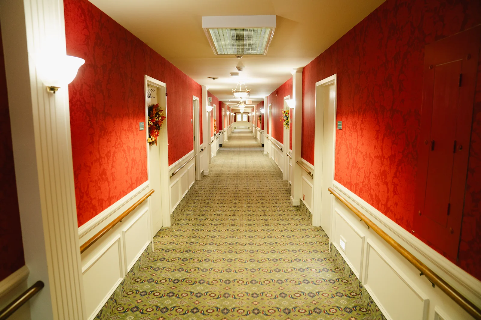 Wesley Manor Assisted Living Community offering assisted living and continuing care retirement community (CCRC) services in Louisville, KY, hallway with red wallpaper