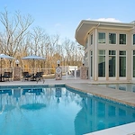 Westhill Newnan Crossing senior living community offering assisted living and memory care in Newnan, GA, outdoor pool with tables and chairs nearby for sitting poolside