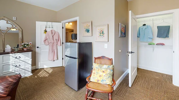 Refrigerator and small chair in one of the bedrooms at Orchard Ridge 