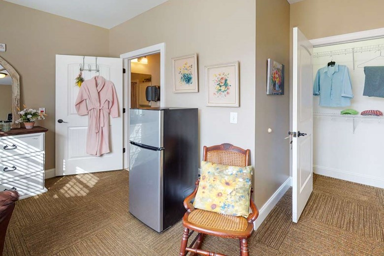 Refrigerator and small chair in one of the bedrooms at Orchard Ridge 