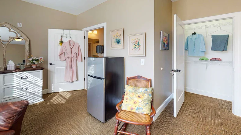 Refrigerator and small chair in one of the bedrooms at Orchard Ridge 