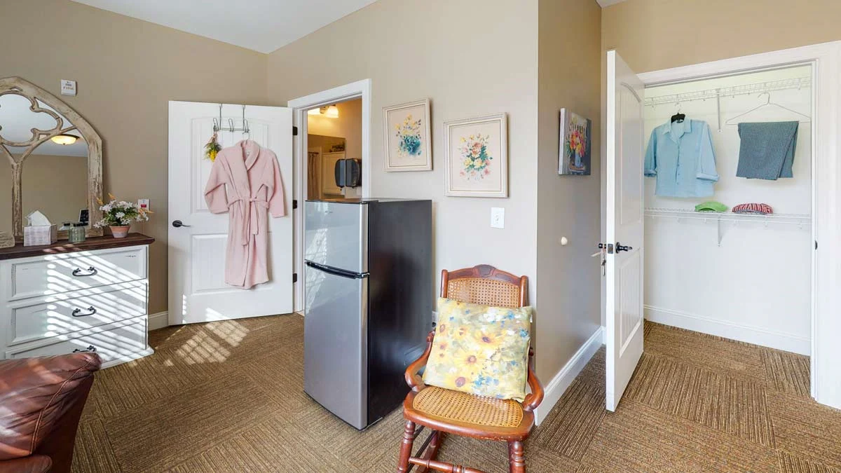 Refrigerator and small chair in one of the bedrooms at Orchard Ridge 