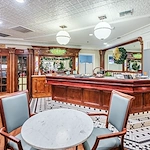 Independent living at Brightmore of Wilmington in Wilmington, NC, community room featuring a large bar with refreshments and a nearby table with two chairs