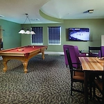Alto Clermont, senior living community offering assisted living, memory care, and respite care in Clermont, FL, activities room featuring a pool table, tv, and table for games