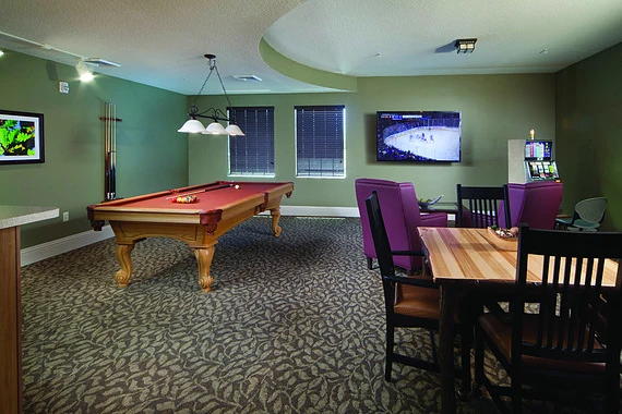 Alto Clermont, senior living community offering assisted living, memory care, and respite care in Clermont, FL, activities room featuring a pool table, tv, and table for games