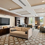 Alto Overland Park, senior living community offering assisted living and memory care in Overland Park, KS, community living room with a variety of seating, a tv, and books