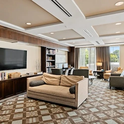 Alto Overland Park, senior living community offering assisted living and memory care in Overland Park, KS, community living room with a variety of seating, a tv, and books