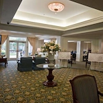 Charter Senior Living of Augusta Gardens senior living community offering assisted living and memory care in Augusta, GA, lobby with cozy seating and a view into the dining area
