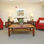 Willoughby Hills Senior Apartments community offering active adult living and independent living in Willoughby Hills, OH, libray with bright red chairs and a brown couch