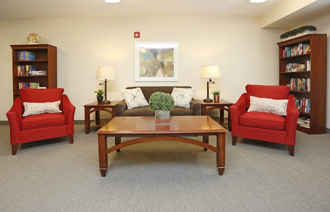 Willoughby Hills Senior Apartments community offering active adult living and independent living in Willoughby Hills, OH, libray with bright red chairs and a brown couch