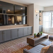 Watermere at Flower Mound senior living community offering active adult living and independent living in Flower Mound, TX, community living room with four mounted TVs for a variety of viewing options