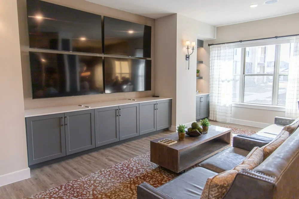 Watermere at Flower Mound senior living community offering active adult living and independent living in Flower Mound, TX, community living room with four mounted TVs for a variety of viewing options