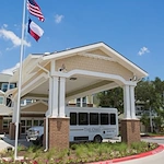 The Oaks Gracious Retirement Living Hawthorn Senior Independent Living in Georgetown, Texas front exterior with transportation bus