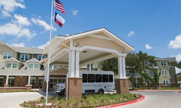 The Oaks Gracious Retirement Living Hawthorn Senior Independent Living in Georgetown, Texas front exterior with transportation bus