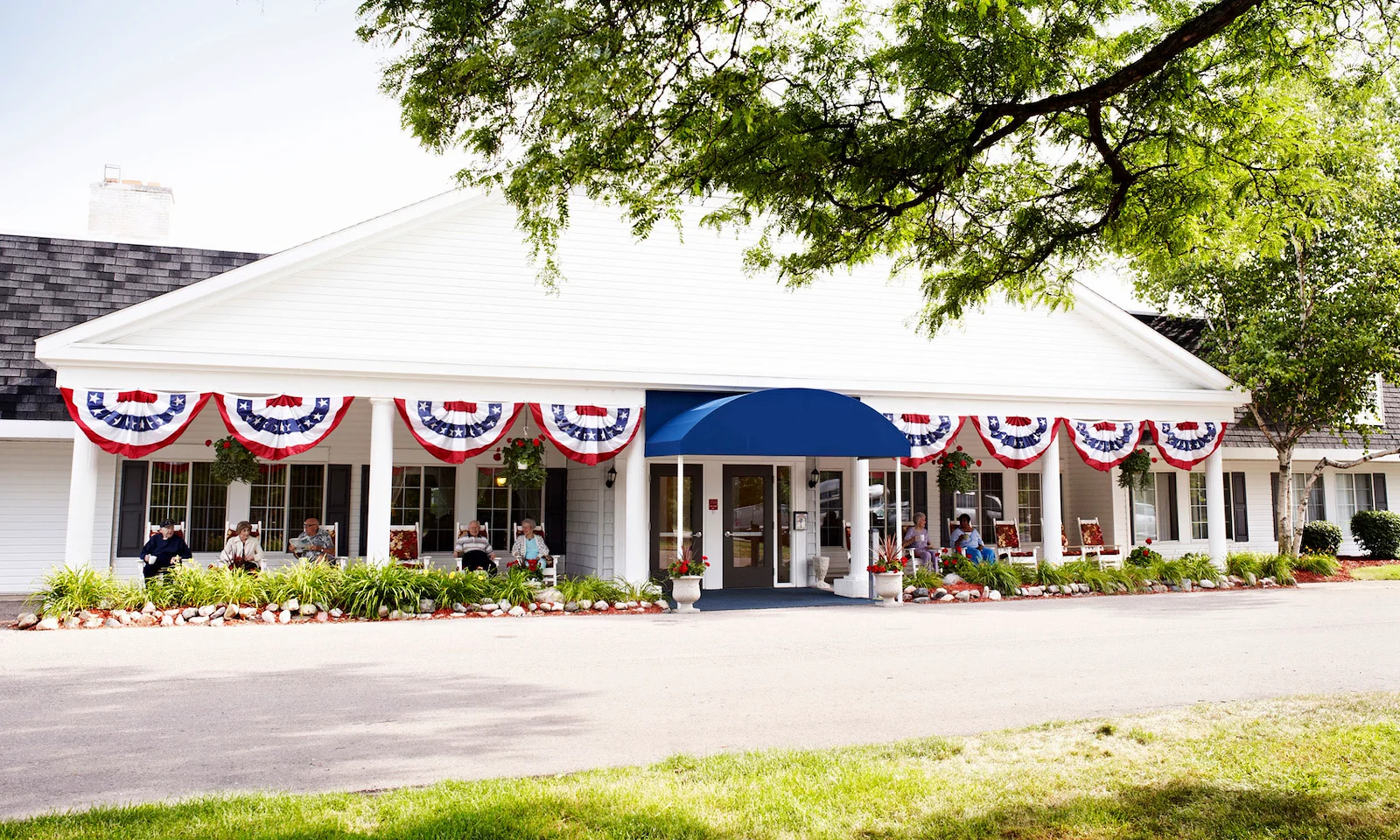 American House Dearborn Heights, senior living community offering independent living and respite care in Dearborn Heights, MI, front exterior with seating on the covered patio