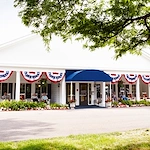American House Dearborn Heights, senior living community offering independent living and respite care in Dearborn Heights, MI, front exterior with seating on the covered patio
