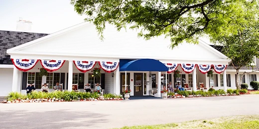 American House Dearborn Heights, senior living community offering independent living and respite care in Dearborn Heights, MI, front exterior with seating on the covered patio