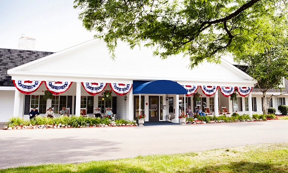 American House Dearborn Heights, senior living community offering independent living and respite care in Dearborn Heights, MI, front exterior with seating on the covered patio