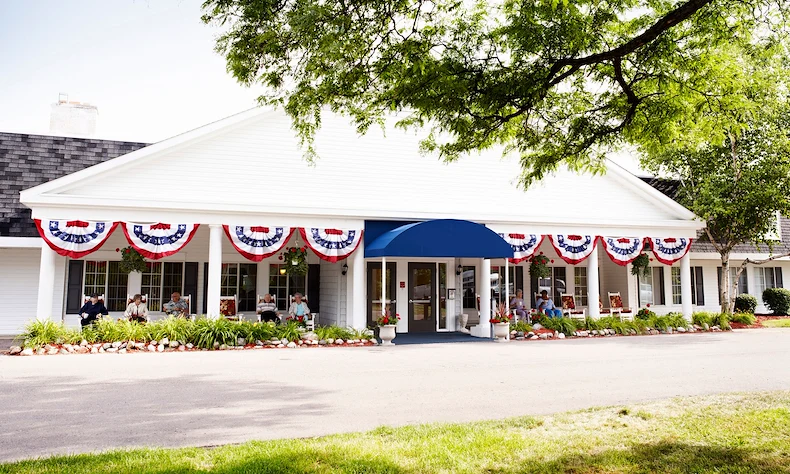American House Dearborn Heights, senior living community offering independent living and respite care in Dearborn Heights, MI, front exterior with seating on the covered patio