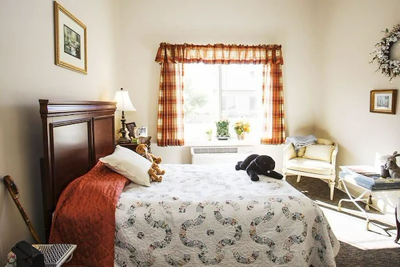 Windsor Heights Senior Living, assisted living and memory care in Beachwood, OH, apartment bedroom with warm natural lighting