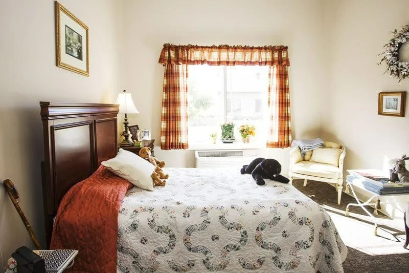 Windsor Heights Senior Living, assisted living and memory care in Beachwood, OH, apartment bedroom with warm natural lighting