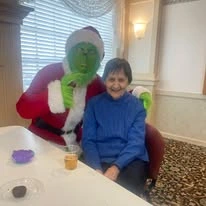 Ascension Living Via Christi Village McLean Senior Living in Wichita, Kansas resident with the Grinch at a Christmas party