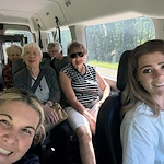 Seniors and staff smiling aboard a community van from Charter Senior Living of Hermitage in Hermitage, TN, heading to an off-site trip, fostering social engagement and active lifestyles in independent living, assisted living, and memory care.