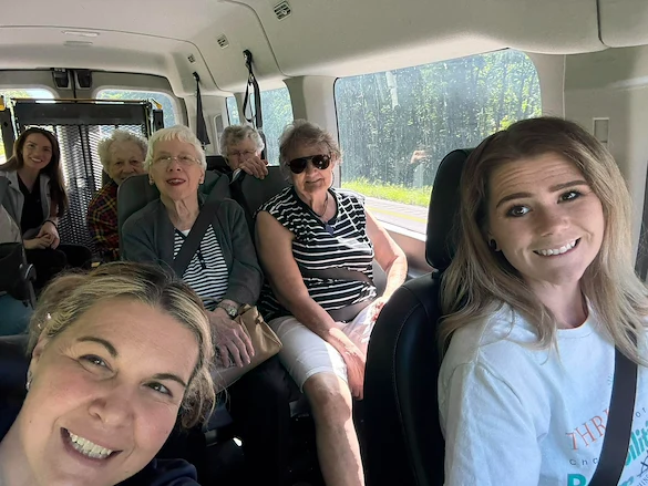 Seniors and staff smiling aboard a community van from Charter Senior Living of Hermitage in Hermitage, TN, heading to an off-site trip, fostering social engagement and active lifestyles in independent living, assisted living, and memory care.