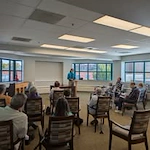 Ascension Living Bethlehem Woods Village senior living community offering independent living, assisted living, and memory care in La Grange Park, IL, residents listening to a speaker