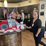 Willow Creek Gracious Retirement Living Hawthorn Senior Independent Living in Chesapeake, Virginia staff member with Independence Day party setup
