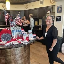 Willow Creek Gracious Retirement Living Hawthorn Senior Independent Living in Chesapeake, Virginia staff member with Independence Day party setup