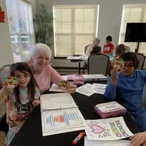 The Highlands Gracious Retirement Living Hawthorn Senior Independent Living in Westborough, Massachusetts residents doing arts and crafts with kids