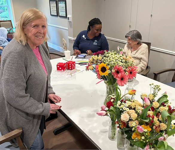 Charter Senior Living of Dedham in Dedham, MA, resident embracing creativity through floral arrangment activitiy