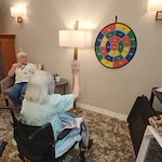 Avamere at St. Helens senior living community offering independent living, assisted living, memory care, and respite care in St. Helens, OR, resident in a wheelchair playing a game