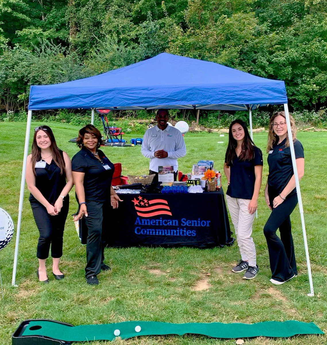 Table and tent with staff at golf course