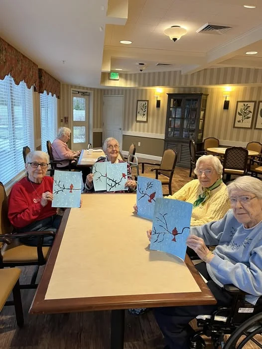 Residents of Viva Senior living showing off their paintings