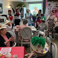 Chateau Valley Center in Renton, WA, residents enjoying entertainment during themed tea party