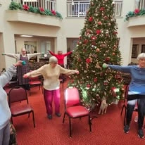 Somerset Lodge Gracious Retirement Living Hawthorn Senior Independent Living in Gladstone, Oregon residents doing a workout class in front of a Christmas tree