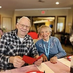 Residents at Kingsley Shores celebrating Valentine's Day with breakfast, gift bags, and live music