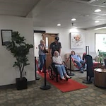 Grande Ronde Retirement Residence senior living community offering independent living, assisted living, and respite care in La Grande, OR, resident in a wheelchair wheeling in on a red carpet