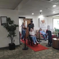 Grande Ronde Retirement Residence senior living community offering independent living, assisted living, and respite care in La Grande, OR, resident in a wheelchair wheeling in on a red carpet