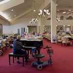 Sterling Heights Gracious Retirement Living Hawthorn Senior Independent Living in Bethlehem, Pennsylvania resident playing the piano in the dining room