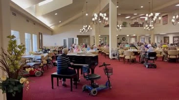 Sterling Heights Gracious Retirement Living Hawthorn Senior Independent Living in Bethlehem, Pennsylvania resident playing the piano in the dining room