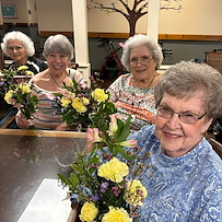 Charter Senior Living of Bowling Green residents smile with their floral arrangements