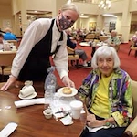 The Carriage House Gracious Retirement Living Hawthorn Senior Independent Living in Oxford, Florida resident being served a meal by a staff member